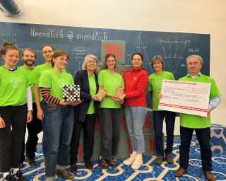 Iris Rudolph, Pressesprecherin der Stadtwerke Halle überreicht die Laternenfest-Spende an Prof. Karin Richter und Axel Hensel, Vorsitzender des Fördervereins Kinder-Forscher e. V., sowie die Studierenden der MLU für Lehramt Mathematik.